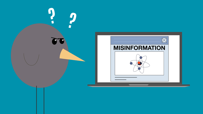 A bird gets confused looking at misinformation on a laptop.